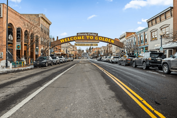 A street with cars parked on the side at The Avenue Lofts Golden Apartments, Golden, CO